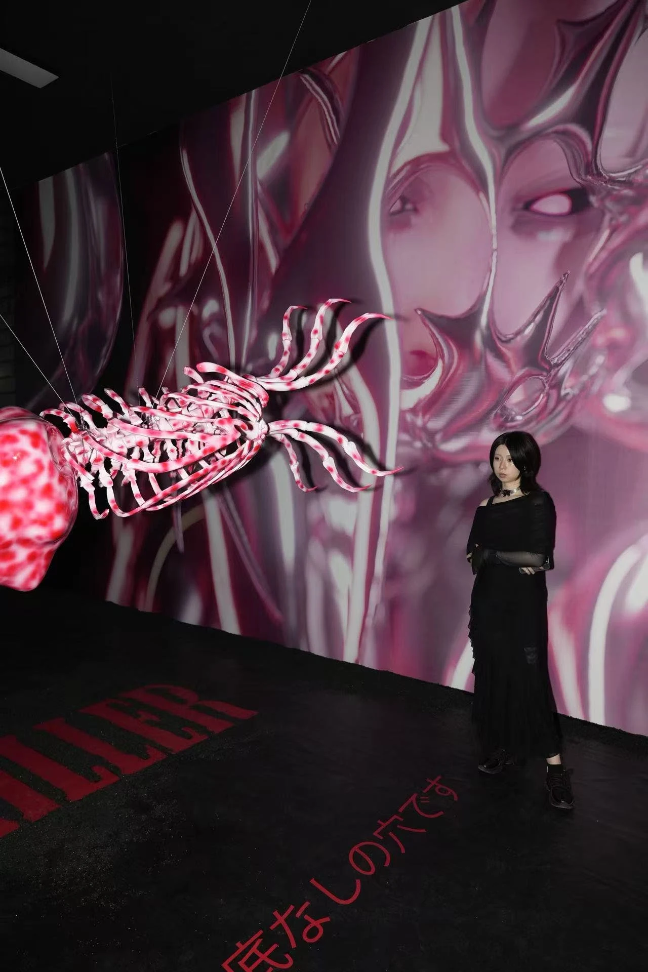 Red projection and black sculpture in the exhibition